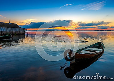 Sunrise on Lake Seliger with an old boat in the foreground. Stock Photo
