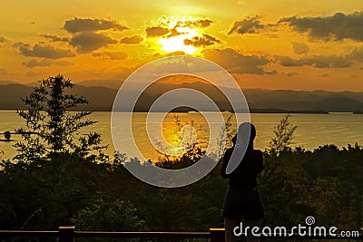 Sunrise morning with black shadow of traveler on lagoon and mountain Stock Photo