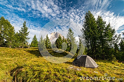 Sunrise morning view of green tent and Tofane mountains Tofana di Rozes in background. Autumn camping in Dolomites, Trentino Alto Stock Photo