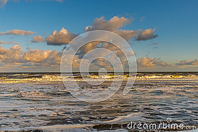 Sunrise North Sea beach of the Netherlands with yellow surf and wave crests Stock Photo