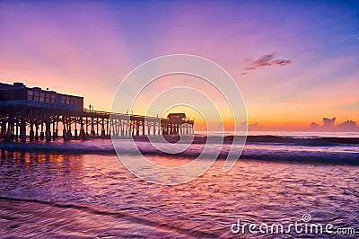 Sunrise over Cocoa Beach Pier in purple blue and orange Stock Photo