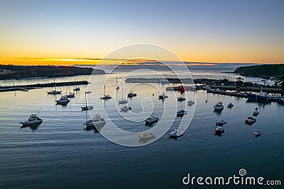 Sunrise over the harbour with low cloud bank and boats Stock Photo