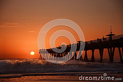 Sunrise over horizon and fishing pier. Stock Photo