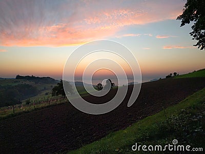 Sunrise over mountain farmland Stock Photo