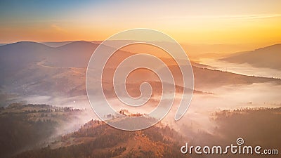 Sunrise over mountain foggy valley. Misty woodland in the morning Stock Photo