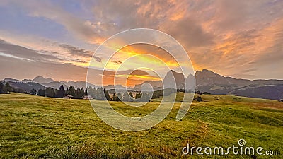 Sunrise paints Dolomites in radiant hues, morning light dances across Alpe di Siusi Stock Photo