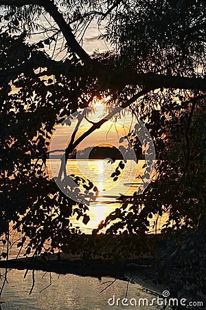 Sunrise through peephole in trees over Rend Lake in Illinois Stock Photo