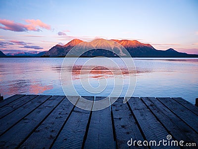 Sunrise at pier with mountains faraway Stock Photo