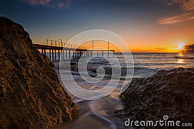 Sunrise between rocks on the bay Stock Photo