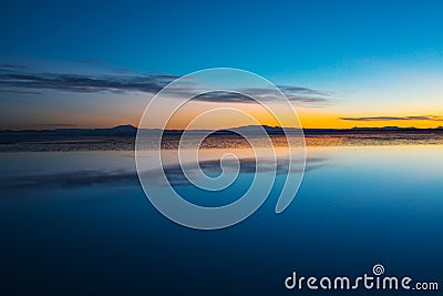 Sunrise on Salar de Uyuni in Bolivia covered with water, salt flat desert and sky reflections Stock Photo