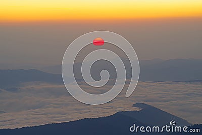 Sunrise scene with red sun over the mountains Stock Photo