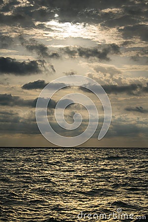 Sunrise at sea, with a dramatic sky full of black clouds. A stormy summer day Stock Photo