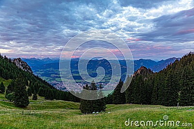 sunrise seen from mountain peak of Gruenten with village of Rettenberg and Alps panorama Stock Photo