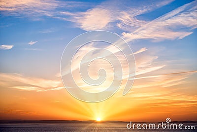 Sunrise with Sun, Sun Rays, Blue Sky, Clouds and Sea Stock Photo