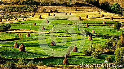 Sunrise in the Transylvania county Romania with fields of haystack Stock Photo