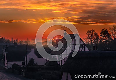 Sunrise in the village of Monkton, Kent, UK. The sun is just appearing behind a cloud producing a rim light and misty haze Stock Photo