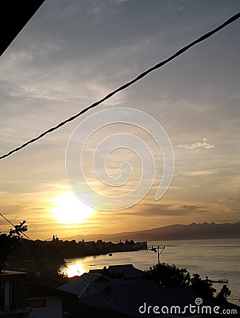 Sunrise village sea sun dark panorama goldensky Stock Photo