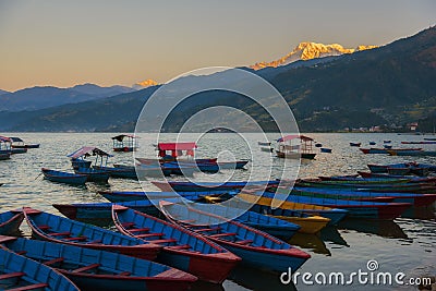 Sunrise with wooden boats on Phewa lake, Pokhara, Nepal. Stock Photo