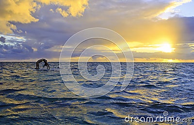 Sunrise yoga on paddle board Stock Photo