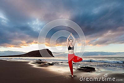 Sunrise yoga session on beach Stock Photo