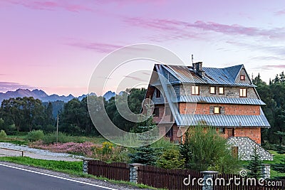 Sunrises over quaint country home beside fence Stock Photo