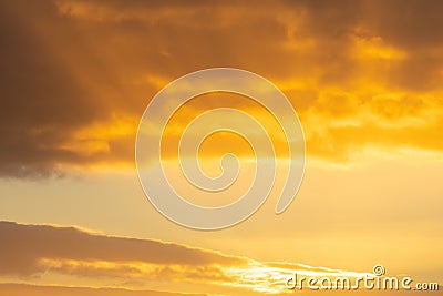 Suns rays shine through golden sky and clouds Stock Photo