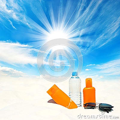 Sunscreen cream and bottle of water over sunny blue sky Stock Photo