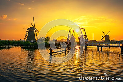 Sunset above a historic drawbridge and old windmills in Kinderdijk, Netherlands Editorial Stock Photo