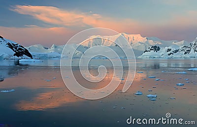 Sunset and alpenglow, mountains and mirror - calm ocean Stock Photo