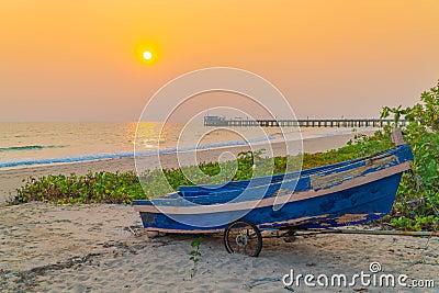 Sunset at anchor fishing boat at low tide Stock Photo