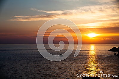 Sunset on the beach with clouds. Calm sea water. Beautiful colors in the sky. Blue and orange shades. Quiet place. Relaxing scene Stock Photo