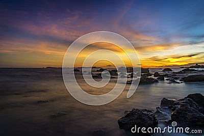 Sunset on the beach with rock islet Stock Photo