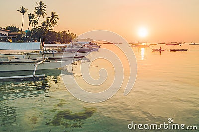 Sunset on the beach with silhouette of banca boat at Panglao Island, Bohol, Philippines Stock Photo