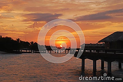 Sunset with beautiful natural sky against the overwater villa at a tropical resort island, Maldives Stock Photo