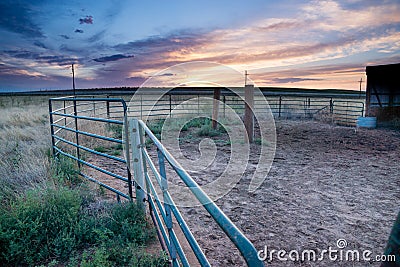 Sunset behind fencing and barn in Eastern Plains Colorado Stock Photo