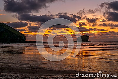 Sunset behind Gull Rock at Portreath in Cornwall Stock Photo