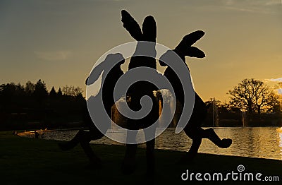 Sunset behind silhouetted dancing hares sculpture. Wisley. Stock Photo