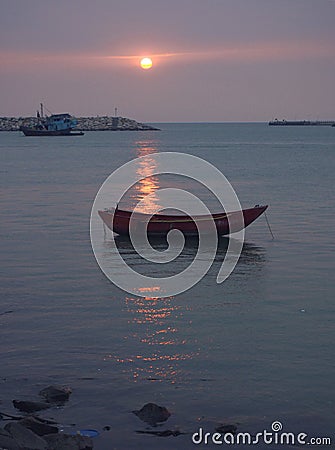 Sunset and Boats on Seashore Stock Photo