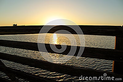 Sunset at bolsa chica wetlands through a wooden bridge Stock Photo