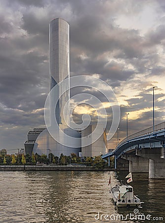 Sunset on the chimney of port cleaning plant in the Odaiba Bay industrial harbor in front of the Rainbow Bridge with ship sailing Editorial Stock Photo