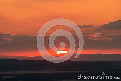 Sunset with clouds over the hills Stock Photo