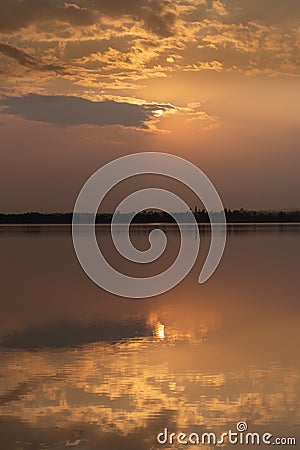 Sunset with clouds on the sky reflected on water Stock Photo