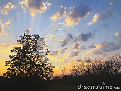 Sunset cloudy sky with picturesque clouds lit by warm sunset sunlight. Country road at sunset Stock Photo