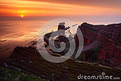 Sunset on the coast. Sea with sun. Rock coast with sun during sunset. Sunset at Helgoland in Germany. Beautiful landscape with ora Stock Photo