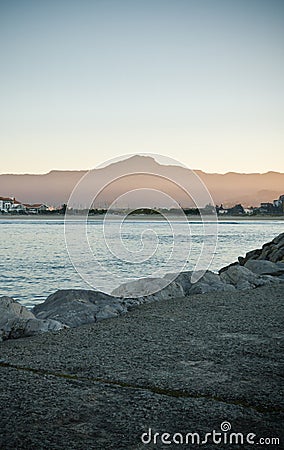 At sunset coastline rocks in satin soft atlantic ocean, mountain trois couronnes in long exposure, basque country, france Editorial Stock Photo