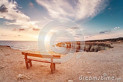 Sunset in Cyprus - Mediterranean Sea coast. Sea Caves near Ayia Napa. the bench in the background of space. you can sit Stock Photo