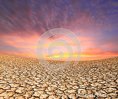 Sunset on the ground dried by dryness Stock Photo