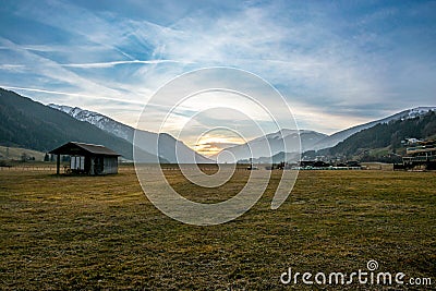 Sunset and illuminated meadow in a valley in Austria Stock Photo