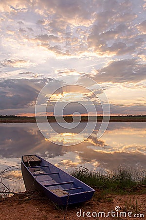 Sunset on the lake. Beautiful sunset behind the storm clouds before a thunder storm above the over lake landscape background. Stock Photo