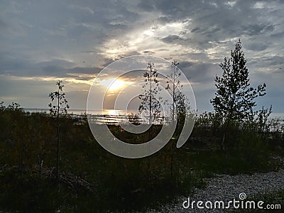 Sunset Lake Michigan north point pebbles waves water sky clouds vegetation beach evening view travel hike adventure scenic Stock Photo